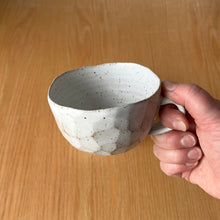 Load image into Gallery viewer, speckled cap cup in hand showing facets, rim and scale