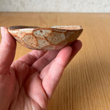 Load image into Gallery viewer, Shino oil dish in hand showing glaze detail on the faceted exerior