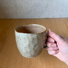 Load image into Gallery viewer, Side view of a wheel-thrown faceted mug, showing the rim and size in hand, BYRNT Ceramics
